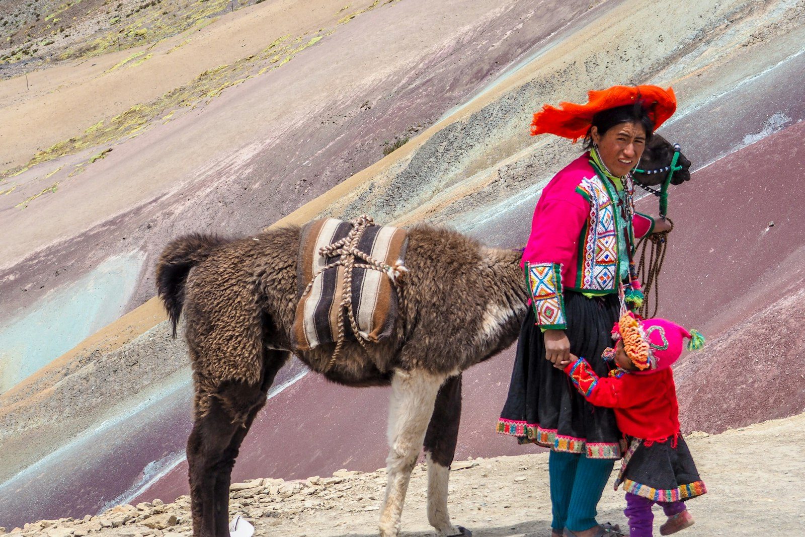 An Andean woman with a llama on Rainbow Mountain