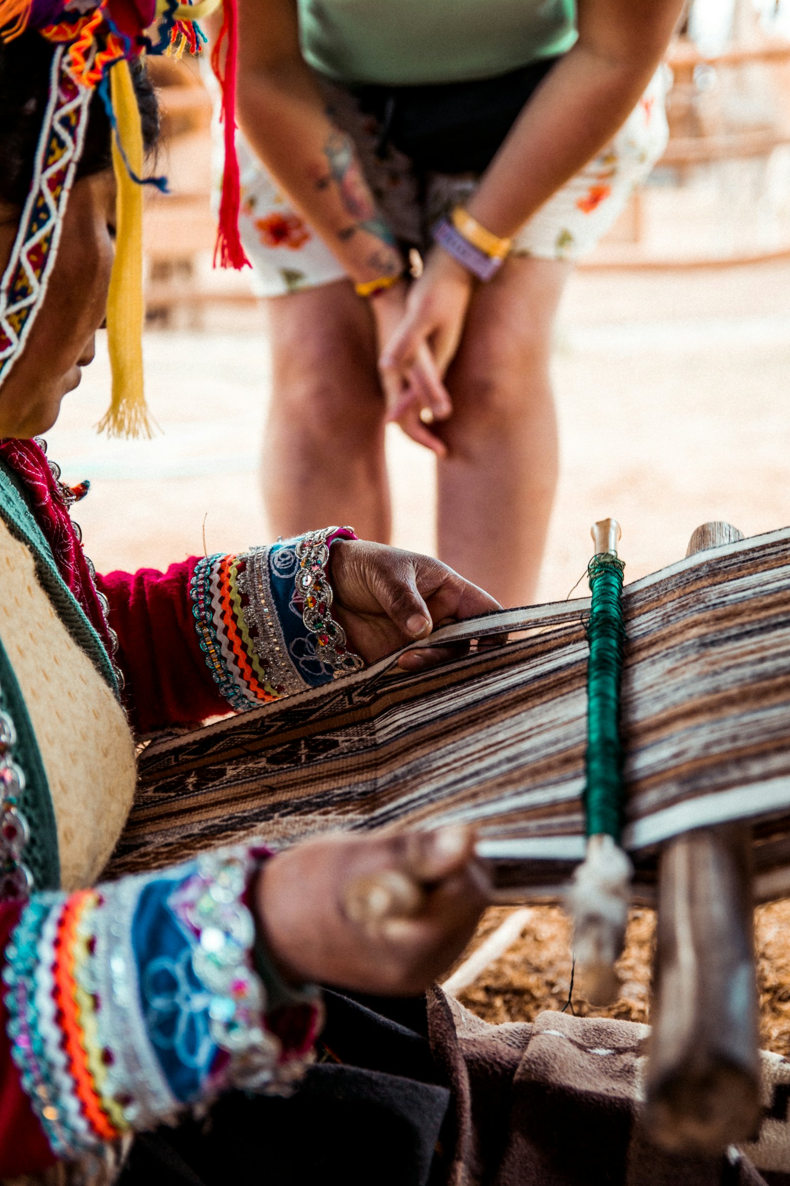Hands working a backstrap loom