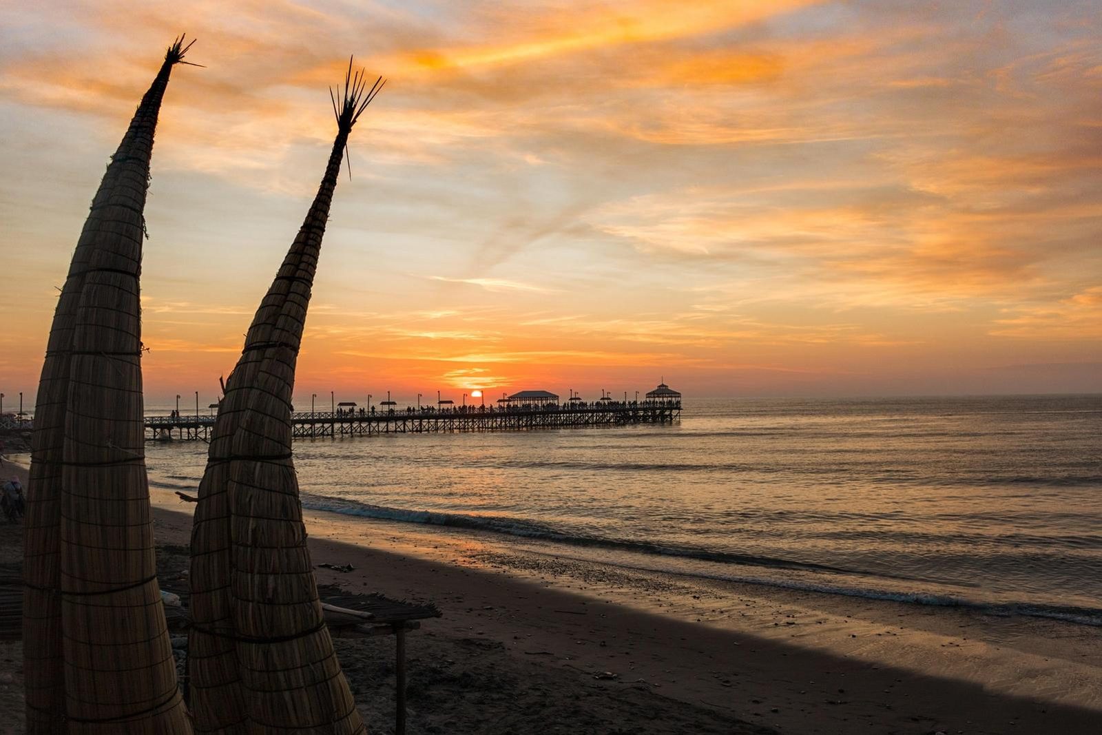 Reed boats on Huanchaco beach at sunset